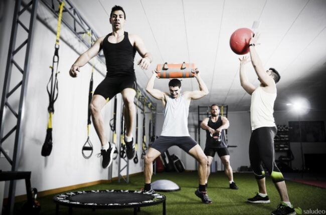 Group of people in action doing crossfit exercises